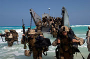 image of moon Marines disembark a Landing Craft Utility ship.