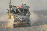 ACH100157M
A British Armed Forces Snatch Land Rover drives down a dirt road in Iraq.