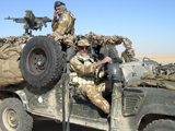ACH100241M
British Army soldiers on patrol in a Land Rover in Iraq.