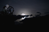 RIT100018S
Telescope pointed out to the night sky with moon and clouds.