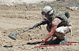 STK100222M
U.S. Army Private uses a metal detector to mark land mines and unexploded ordnance.