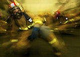 STK100972M
Lithographer braces for shock during a simulated attack and general quarters drill.