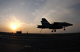 STK101153M
An F/A-18C Hornet makes an arrested landing as the sun sets.