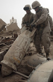 STK101910M
Marines lift up a bomb to determine if it still poses a threat.