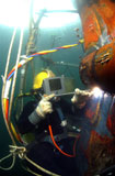 STK102232M
U.S. Navy Diver welds a repair patch on the submerged bow of the USS Ogden.