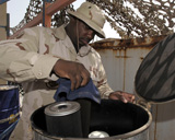 STK102438M
Sergeant prepares a 55-gallon drum of used engine oil for inspection.