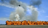 STK102488M
Pyrotechnics explode while an F-15 flies over to simulate an air-to-ground attack.