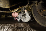 STK102689M
An Airman inspects the undercarriage of an F-350 truck.