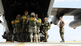 STK102976M
Paratroopers gather around the back of a C-130 Hercules for a last minute briefing.