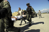 STK103414M
U.S. Airmen offload injured people from a C-130 Hercules aircraft.