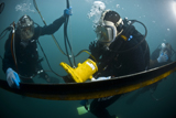 STK103696M
U.S. Navy Diver instructs a Barbados coast guard diver on using a hydraulic grinder underwater.