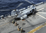 STK103860M
U.S. Marines board a CH-46 Sea Knight helicopter on the flight deck of USS Peleliu.