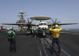 STK104654M
A plane director guides an E-2C Hawkeye onto the catapult for launch.