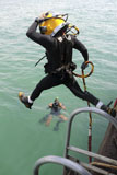 STK104727M
A photographer documents a Navy diver as he enters the water.