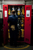 STK104890M
Fireman stows a self-contained breathing apparatus in a locker.