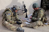 STK105385M
U.S. soldiers count money found while searching a house in Afghanistan.