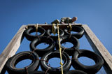 STK105536M
A soldier climbs over a tire tower on an obstacle course.
