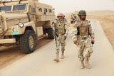 STK105766M
Iraqi army soldiers walk beside an MRAP vehicle in Iraq.