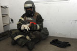 STK105775M
Airman dons his chemical warfare defense ensemble.