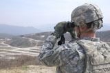 STK105946M
Soldier observes an adjust fire mission through binoculars.