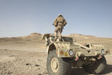 STK106139M
Soldier climbs a damaged Husky Tactical Support Vehicle.