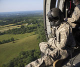 STK106340M
An Army crew chief looks out the door of a UH-60 Black Hawk helicopter.