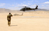 STK106538M
Brigade aviation officer salutes as a UH-60 Black Hawk helicopter lifts off.