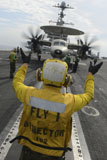 STK106707M
Aviation Boatswain's Mate directs an E-2C Hawkeye aboard USS John C. Stennis.