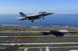 STK106718M
An F/A-18F Super Hornet flies over the flight deck of USS George H.W. Bush.