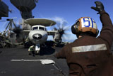 STK106794M
A Sailor signals to pilots of an E-2C Hawkeye aboard USS John C. Stennis.