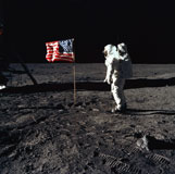 STK200086S
An astronaut stands next to the American flag during an Apollo 11 moonwalk.