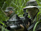 TWE300017M
U.S. Special Forces soldiers patrol through tall grass during combat.