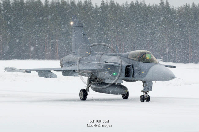 A Swedish JAS 39 Gripen fighter jet preparing for takeoff on a runway.