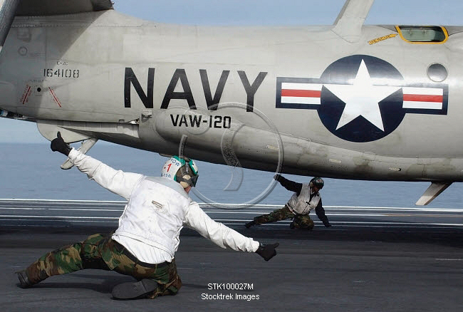 U.S. Navy Sailors give the thumbs up signal before launching a E-2C ...