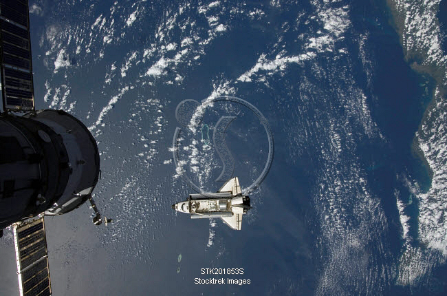 Space Shuttle Endeavour backdropped by a blue and white Earth ...